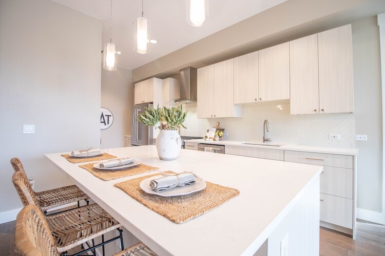 Open concept kitchen with KitchenAid appliances, a gas range, quartz countertops, and a kitchen island.